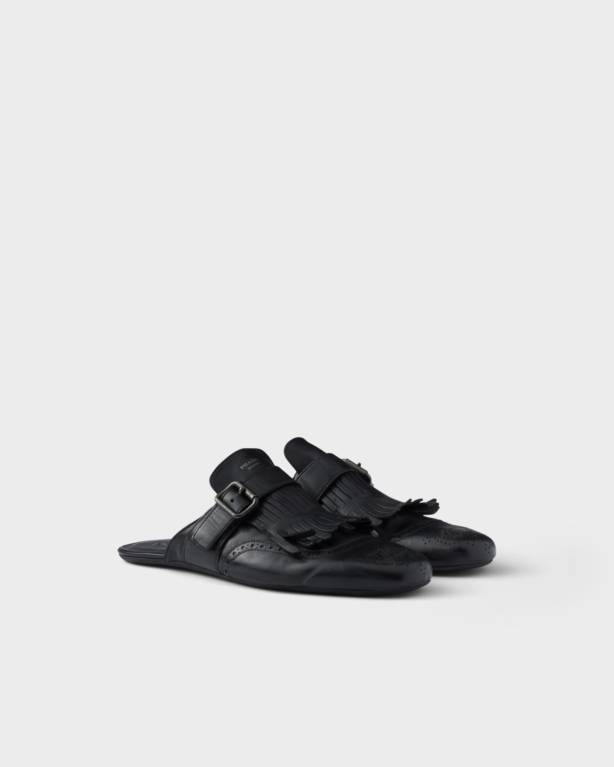 Black Shuffle Antiqued Leather Mules With Buckled Strap And Fringe