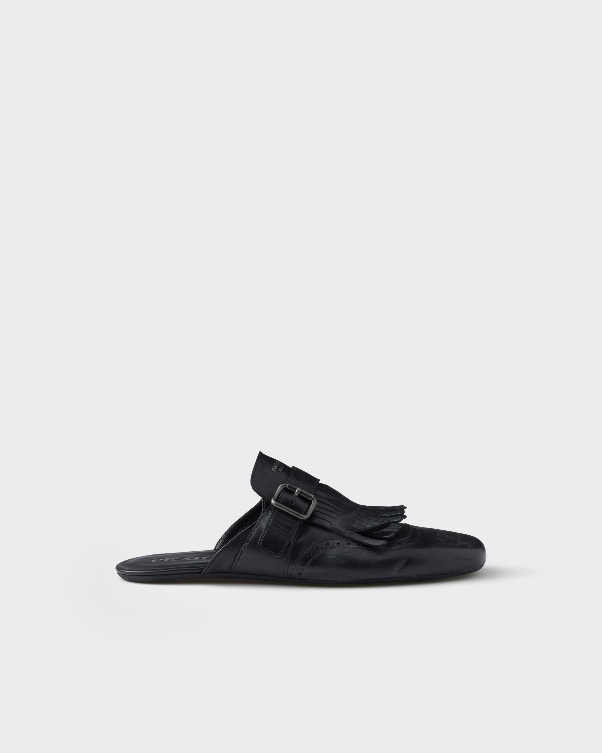 Prada Shuffle antiqued leather mules with buckled strap and fringe