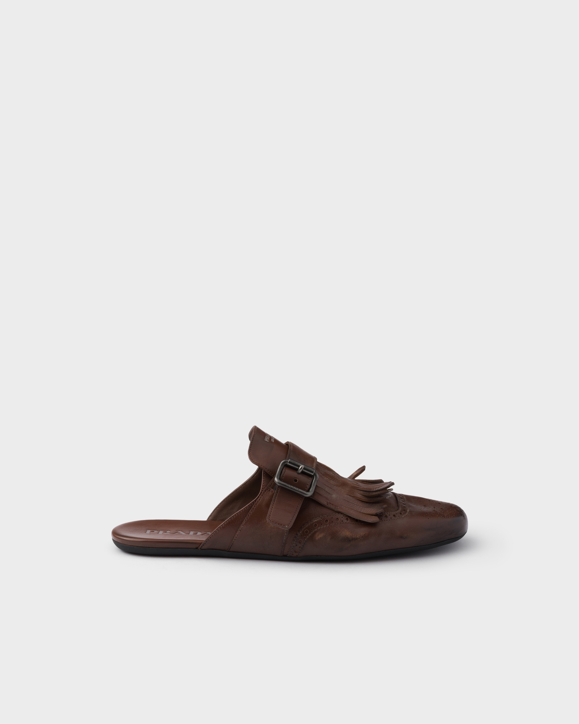 Prada Shuffle antiqued leather mules with buckled strap and fringe