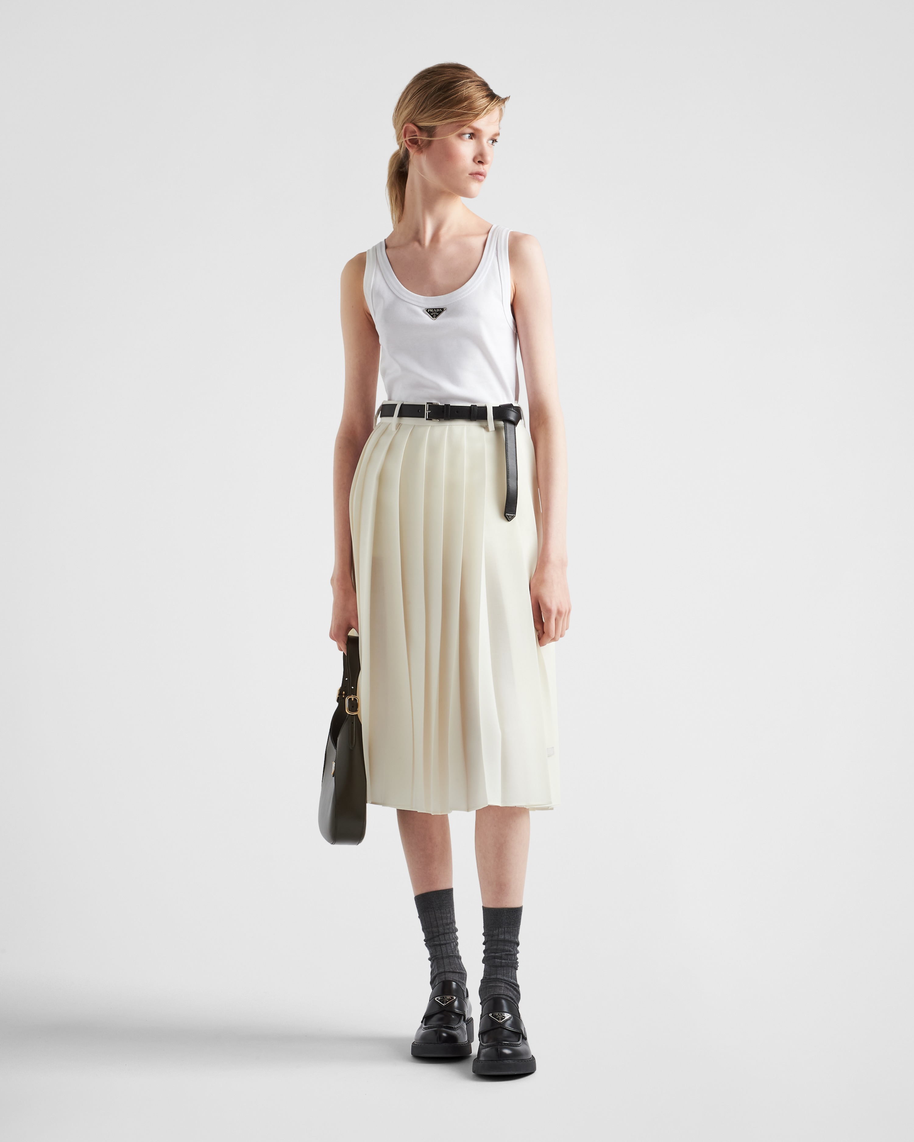 Prada AW22 runway look white logo tank top. The white menswear style plain rib knitted white tank top comes in a slim fit with the iconic Prada triangle logo plaque at the centre. 